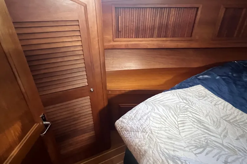  Yacht Photos Pics Wooden interior of 2005 Sabre Flybridge yacht cabin with bed and closet.