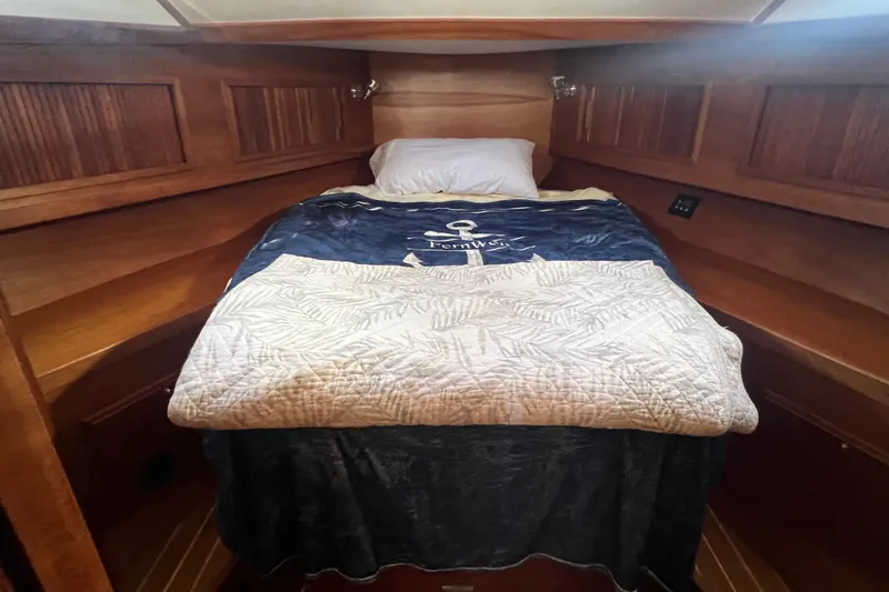  Yacht Photos Pics Cozy cabin interior of 2005 Sabre Flybridge with wooden paneling and comfortable bedding.