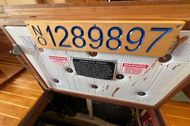  Yacht Photos Pics Engine compartment of 2005 Sabre Flybridge with registration number 1289897 and warning signs.