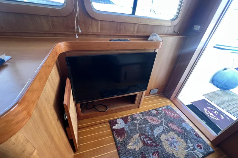  Yacht Photos Pics Interior of 2005 Sabre Flybridge yacht with TV, wooden cabinetry, and floral rug.