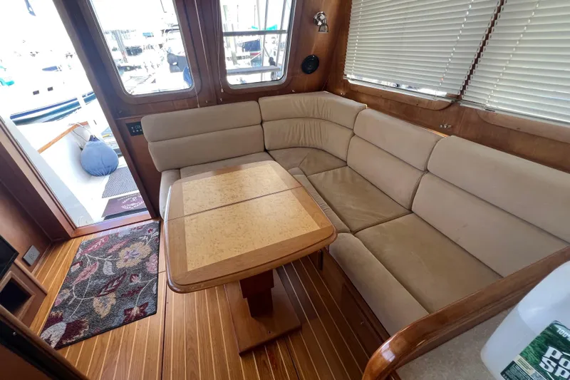  Yacht Photos Pics 2005 Sabre Flybridge interior with beige seating, wooden table, and floral rug.