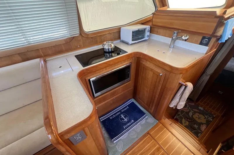  Yacht Photos Pics 2005 Sabre Flybridge yacht kitchen with stove, microwave, and sink.