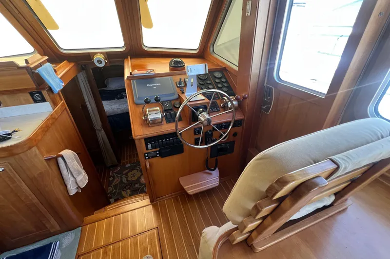  Yacht Photos Pics 2005 Sabre Flybridge helm with wooden interior, steering wheel, and navigation equipment.
