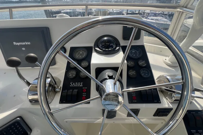  Yacht Photos Pics 2005 Sabre Flybridge helm with steering wheel, gauges, and Raymarine navigation system.
