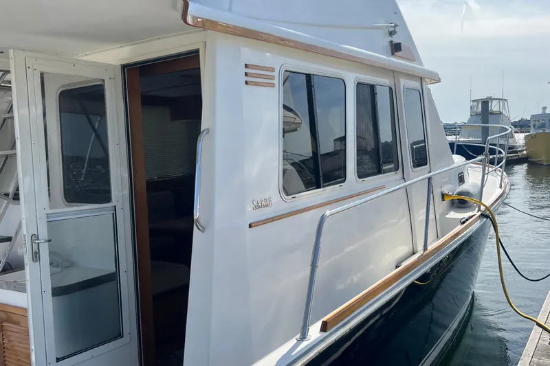  Yacht Photos Pics 2005 Sabre Flybridge yacht docked, showcasing sleek design and spacious cabin entry.