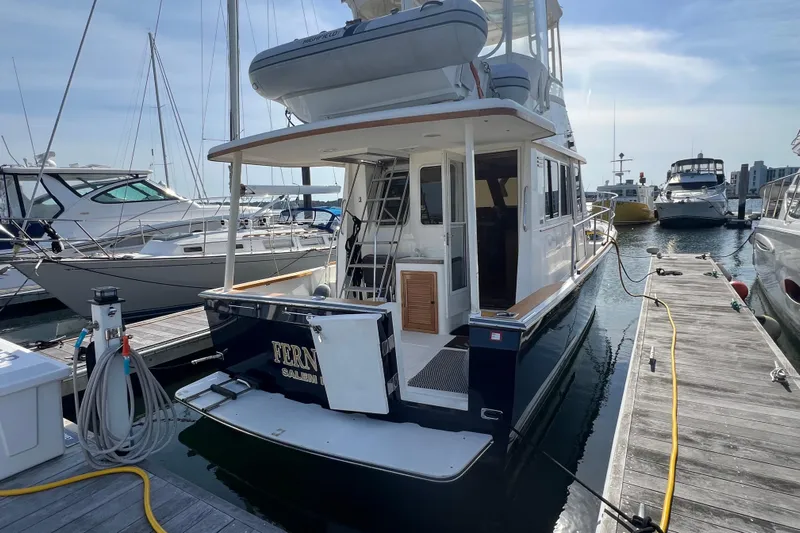  Yacht Photos Pics 2005 Sabre Flybridge yacht docked at marina, rear view with ladder and equipment.