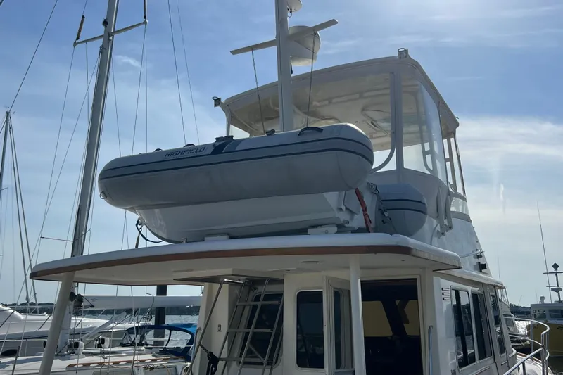  Yacht Photos Pics 2005 Sabre Flybridge yacht with dinghy on top, docked at marina under clear sky.
