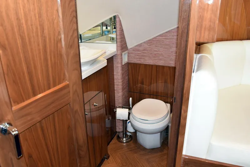  Yacht Photos Pics Luxurious bathroom in 2019 Viking 80 Skybridge yacht with wood accents and modern fixtures.