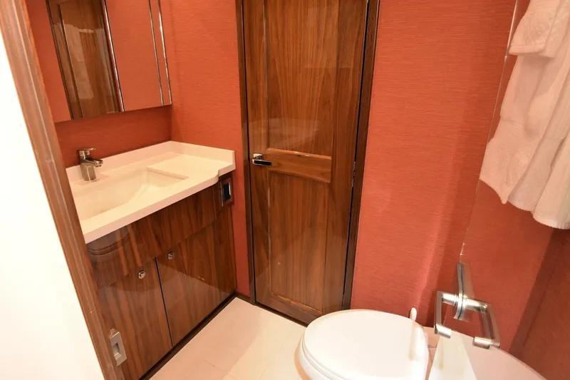  Yacht Photos Pics Luxurious bathroom in 2019 Viking 80 Skybridge yacht with wood accents and modern fixtures.