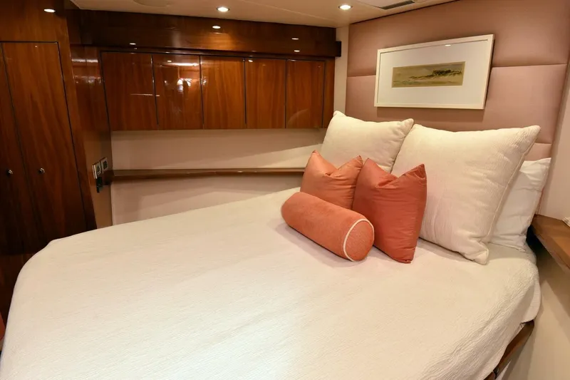  Yacht Photos Pics Luxurious bedroom interior of 2019 Viking 80 Skybridge yacht with elegant wood finishes.