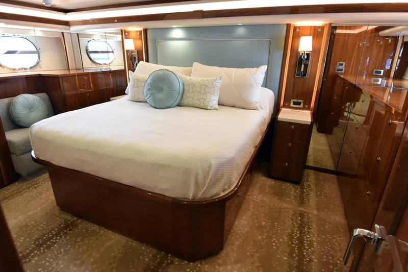  Yacht Photos Pics Luxurious bedroom interior of 2019 Viking 80 Skybridge yacht with elegant wood finishes.