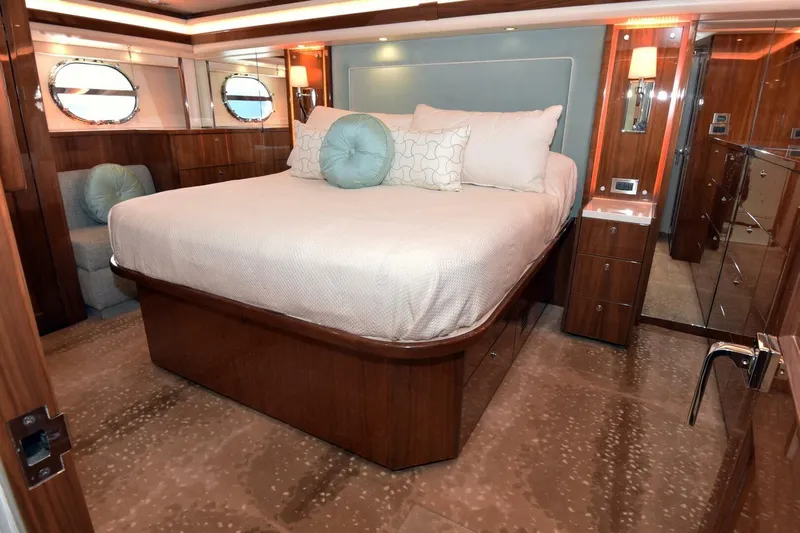  Yacht Photos Pics Luxurious bedroom interior of 2019 Viking 80 Skybridge yacht with elegant wood finishes.