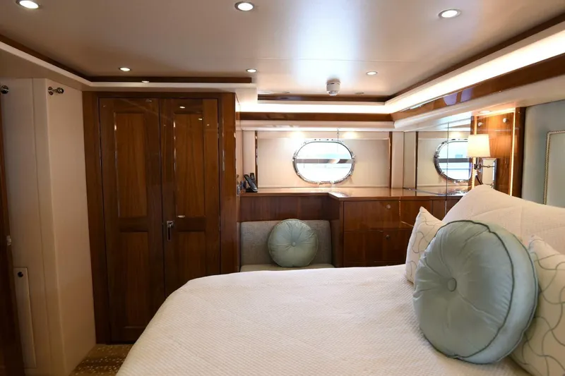  Yacht Photos Pics Luxurious bedroom interior of 2019 Viking 80 Skybridge yacht with elegant wood finishes.