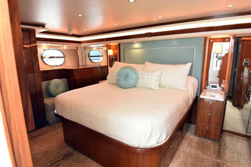  Yacht Photos Pics Luxurious bedroom interior of 2019 Viking 80 Skybridge yacht with elegant wood finishes.