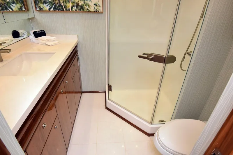  Yacht Photos Pics Luxurious bathroom in 2019 Viking 80 Skybridge yacht with glass shower and elegant vanity.