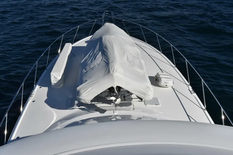  Yacht Photos Pics 2019 Viking 80 Skybridge yacht bow with covered equipment on open water.