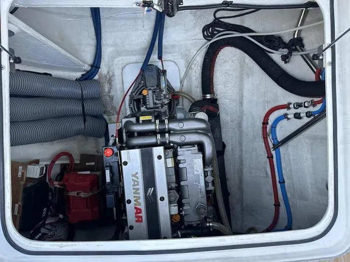 Tranquillity Yacht Photos Pics Engine compartment of a 2022 Excess 15 yacht, featuring a Yanmar engine and various hoses.