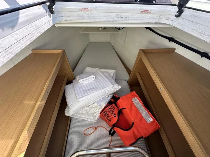 Tranquillity Yacht Photos Pics Interior of 2022 Excess 15 boat cabin with life jacket and folded linens.