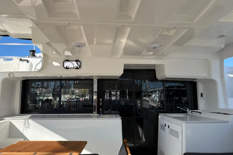  Yacht Photos Pics 2022 Lagoon 46 yacht interior with modern kitchen and seating area.