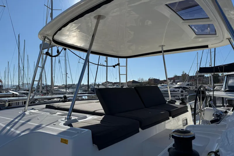  Yacht Photos Pics 2022 Lagoon 46 catamaran with spacious deck and seating area in marina.