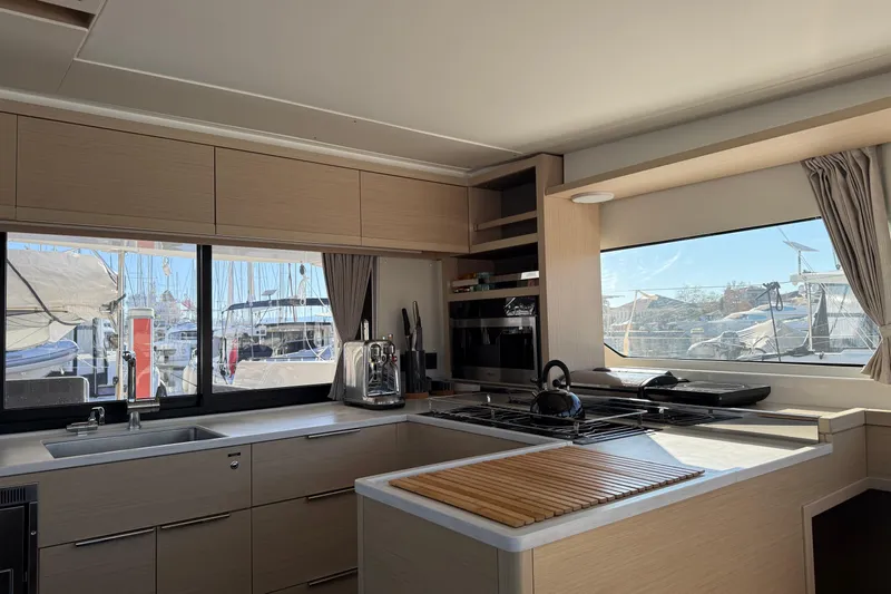  Yacht Photos Pics Modern kitchen interior of 2022 Lagoon 46 yacht with marina view.