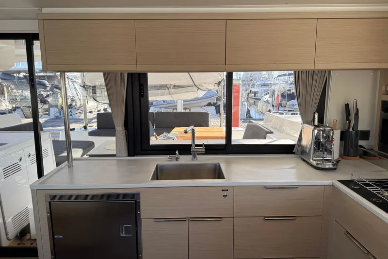  Yacht Photos Pics Modern kitchen interior of 2022 Lagoon 46 yacht with sleek design and marina view.