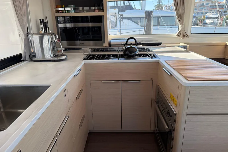  Yacht Photos Pics Modern kitchen interior of 2022 Lagoon 46 yacht with appliances and sleek design.