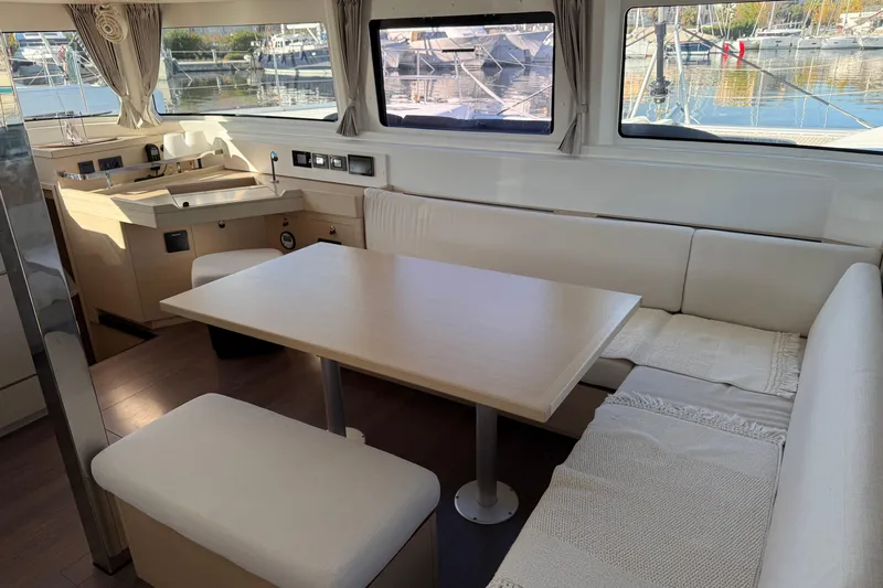  Yacht Photos Pics Interior of 2022 Lagoon 46 catamaran with modern dining area and panoramic windows.