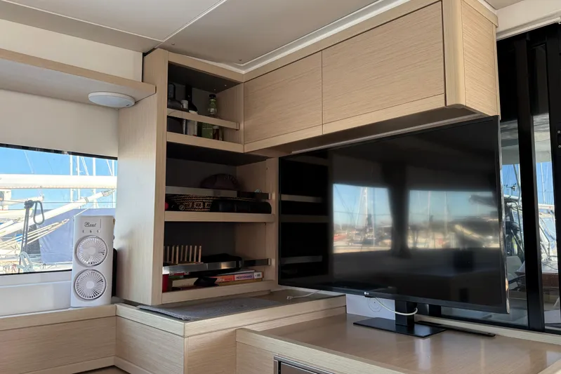  Yacht Photos Pics Interior of 2022 Lagoon 46 yacht with modern cabinetry and large TV screen.