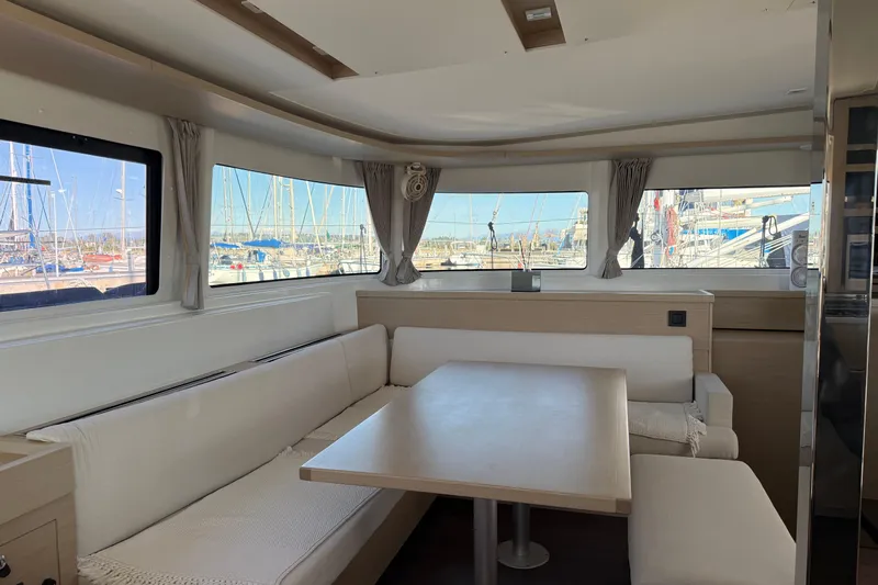  Yacht Photos Pics Interior of 2022 Lagoon 46 catamaran with spacious seating and marina view.