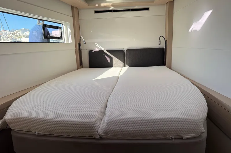  Yacht Photos Pics Luxurious cabin interior of 2022 Lagoon 46 yacht with comfortable bed and modern design.