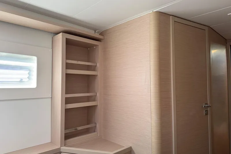  Yacht Photos Pics Interior of 2022 Lagoon 46 yacht with wooden shelves and door.
