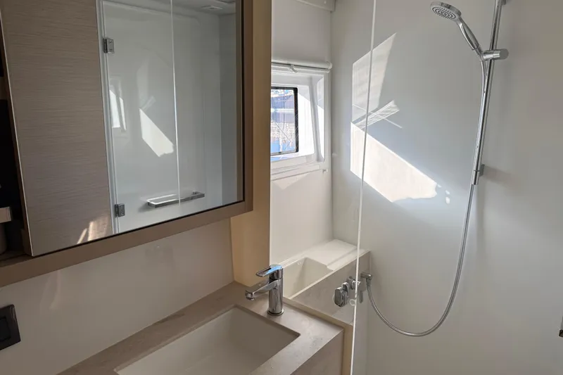  Yacht Photos Pics Modern bathroom interior of 2022 Lagoon 46 yacht, featuring sleek shower and vanity.