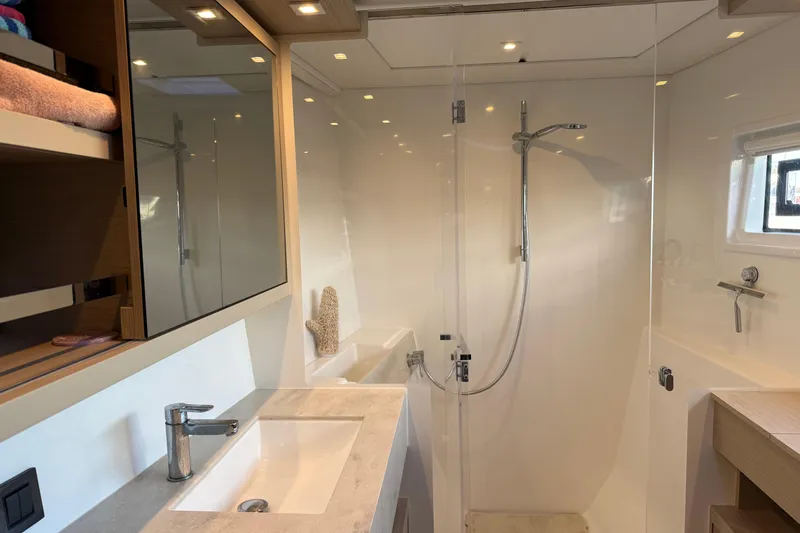  Yacht Photos Pics Luxurious bathroom in 2022 Lagoon 46 yacht with modern fixtures and spacious shower.