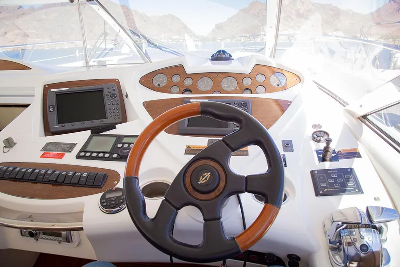 Burn N Daylight Yacht Photos Pics 1999 Sunseeker Predator 58 yacht helm with wooden steering wheel and navigation instruments.