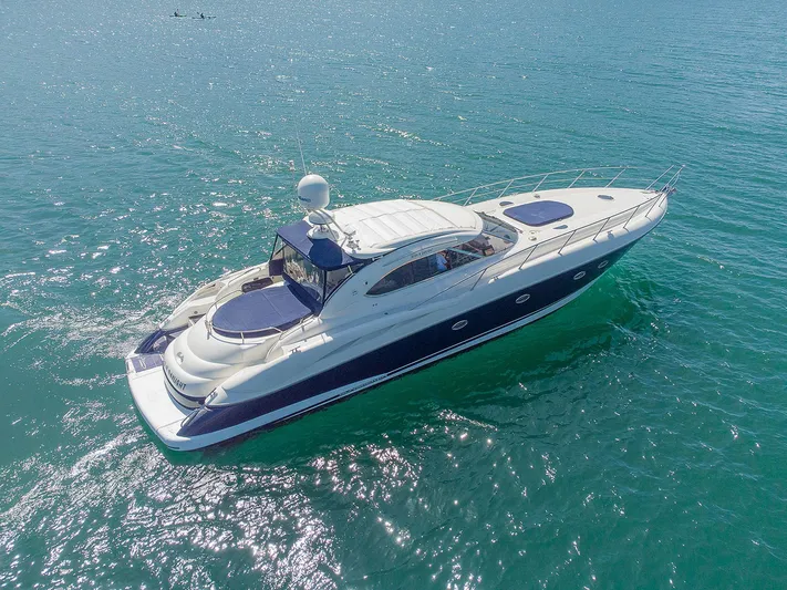 Burn N Daylight Yacht Photos Pics Sunseeker Predator 58 yacht, 1999 model, cruising on clear blue water.