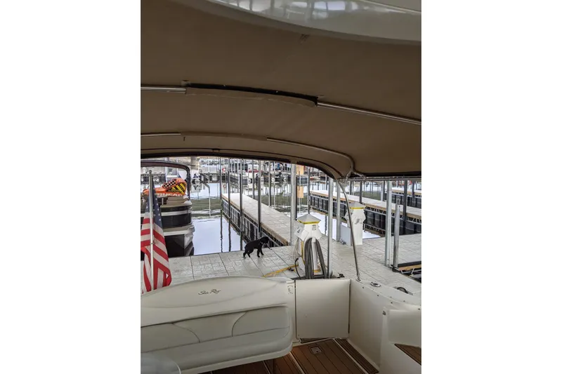 Lottie-da Yacht Photos Pics 2004 Sea Ray 380 Sundancer docked at marina with American flag and dog on pier.