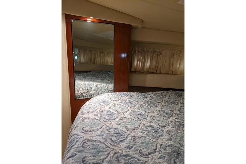 Lottie-da Yacht Photos Pics Interior cabin of 2004 Sea Ray 380 Sundancer with patterned bedding and mirror.