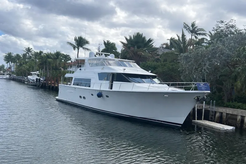 Harbor Lady Yacht Photos Pics 2005 Pacific Mariner Raised Pilothouse Motoryacht docked by palm trees under cloudy sky.