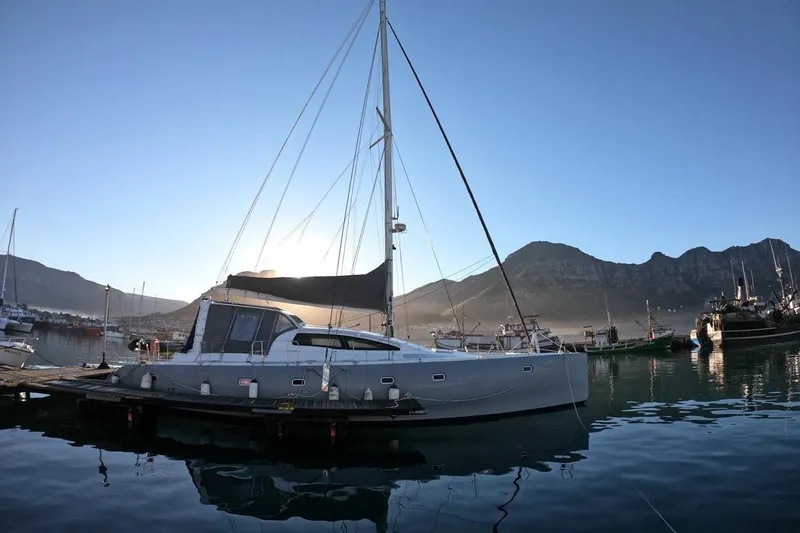 Conquest Yacht Photos Pics 2006 Maxim Yachts 57 sailboat docked in a serene marina with mountain backdrop.