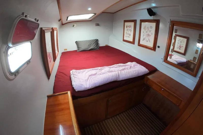 Conquest Yacht Photos Pics Cozy cabin interior of 2006 Maxim Yachts 57 with red bedding and wooden accents.