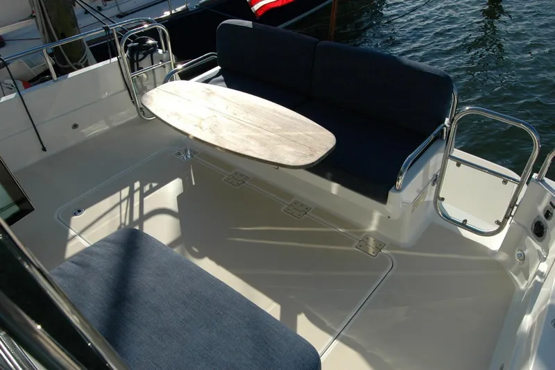 Serendipity Yacht Photos Pics 2019 Sabre 38 Salon Express deck with seating and table, docked by water.