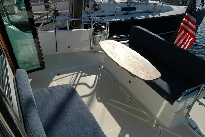 Serendipity Yacht Photos Pics 2019 Sabre 38 Salon Express yacht deck with seating and table, American flag visible.