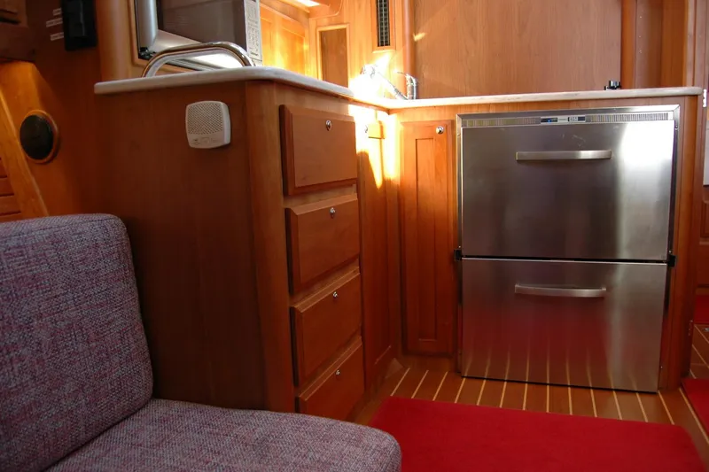 Serendipity Yacht Photos Pics 2019 Sabre 38 Salon Express interior with stainless steel fridge and wooden cabinetry.