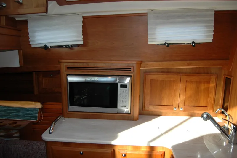 Serendipity Yacht Photos Pics 2019 Sabre 38 Salon Express interior with microwave, wooden cabinets, and sink.