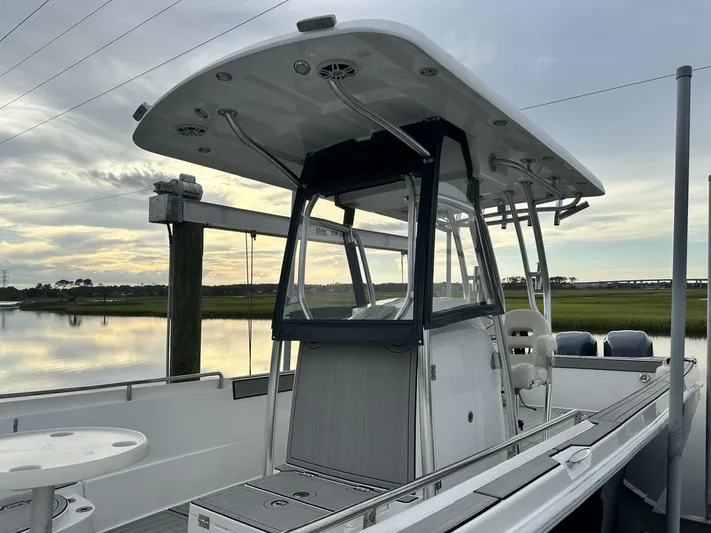  Yacht Photos Pics Custom Shark Fin R321 boat, 2023 model, docked by serene waters under a cloudy sky.