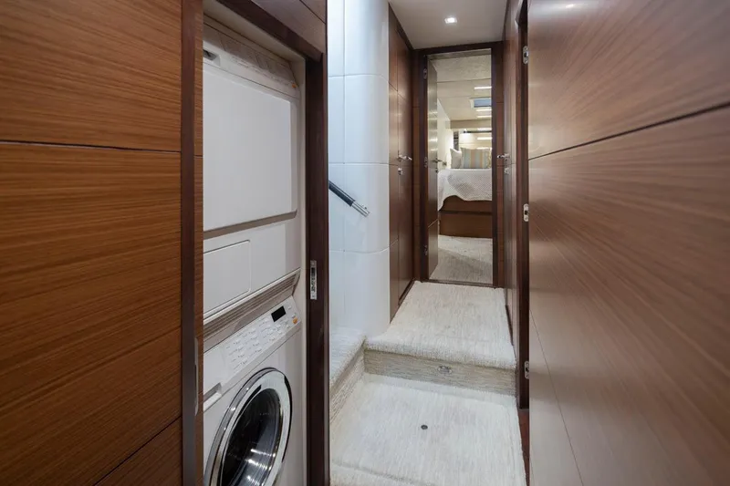 Crescent Moon Yacht Photos Pics Laundry area in 2017 Ocean Alexander 70E Motoryacht with wood paneling and hallway view.