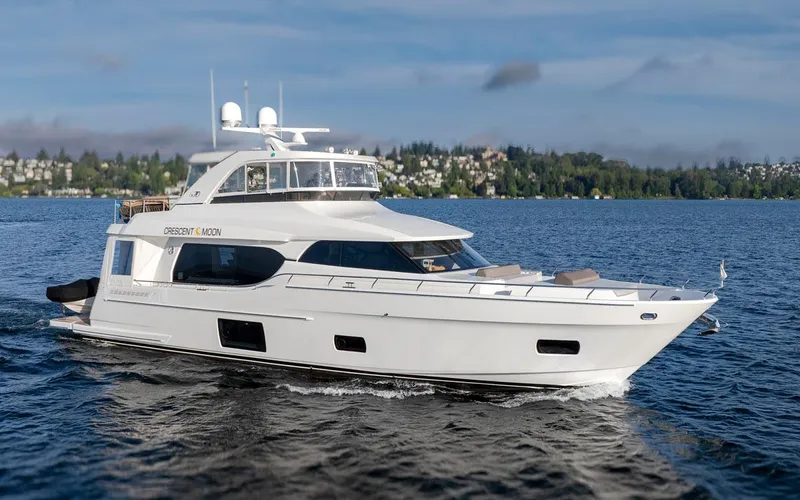 Crescent Moon Yacht Photos Pics 2017 Ocean Alexander 70E Motoryacht cruising on a serene lake with scenic background.