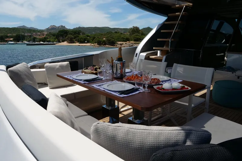 Yacht Photos Pics Luxurious dining setup on 2017 Riva 76 Perseo yacht, overlooking serene coastal waters.