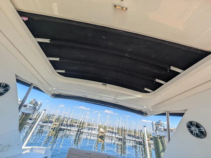  Yacht Photos Pics 2019 Sea Ray Sundancer 320 boat interior with open sunroof at marina.
